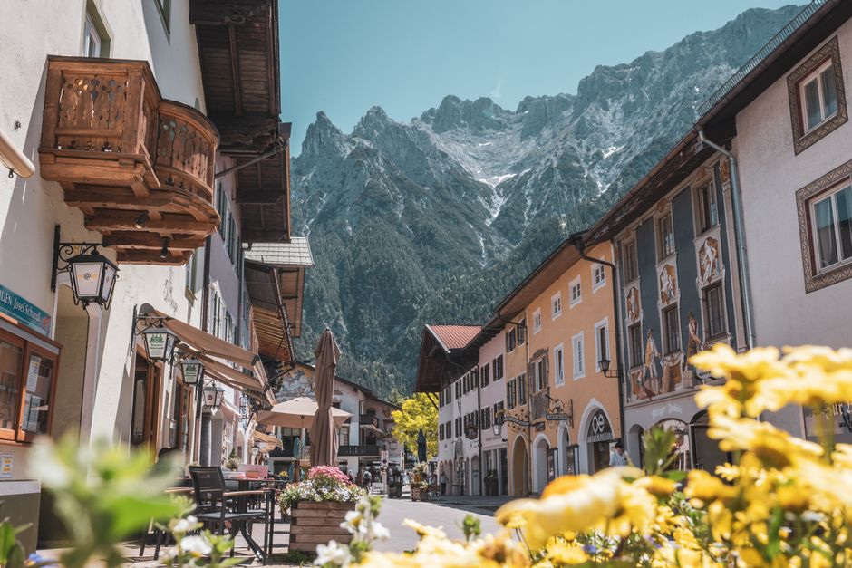 Picturesque street in Mittenwald, Germany showcasing traditional Bavarian architecture with impressive mountain backdrop.