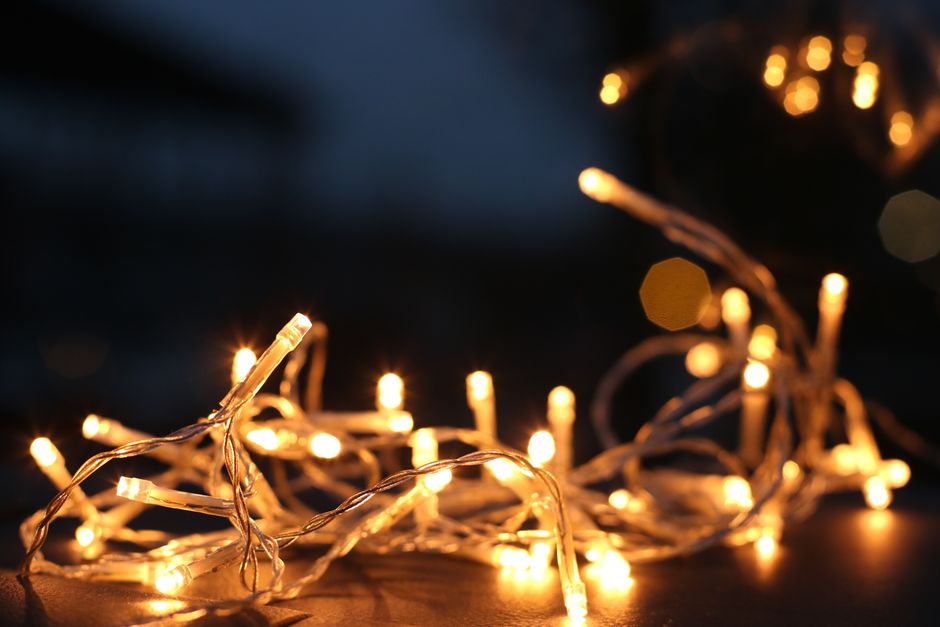 Close-up of warm LED string lights glowing against a dark background.