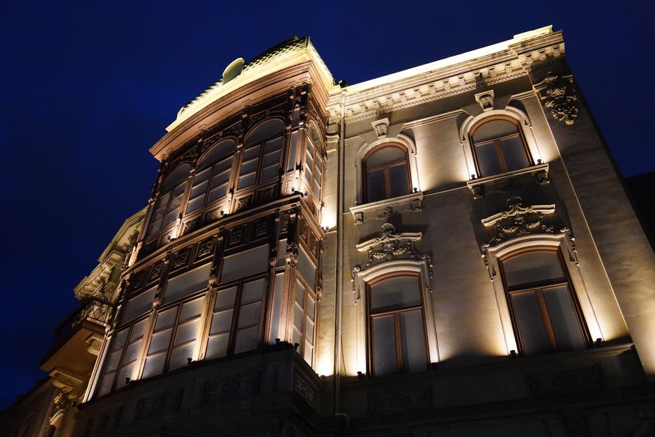 Dramatic view of a historic building's facade beautifully lit against a deep blue night sky.
