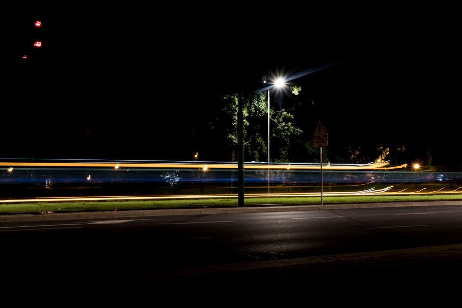 Night highway scene with light streaks from passing cars in a long exposure shot.