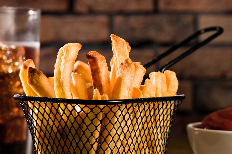 Appetizing close-up of golden french fries in a stylish metal basket, perfect for culinary lovers.