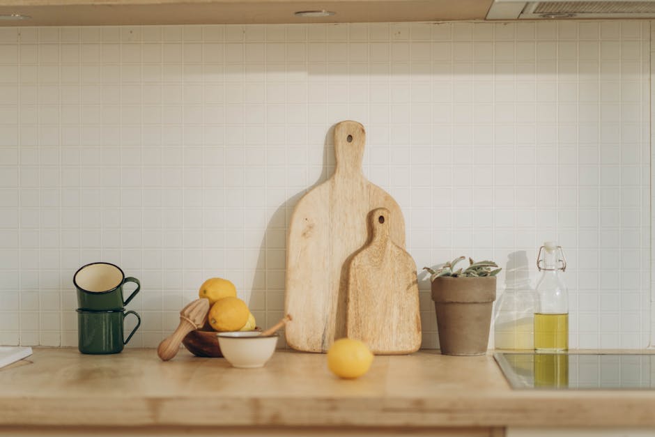 Warm kitchen scene featuring cutting boards, lemons, and cups on a wooden counter.