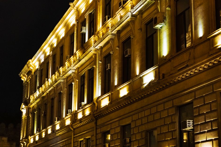 Elegant facade of a historic building lit by warm lights during nighttime.