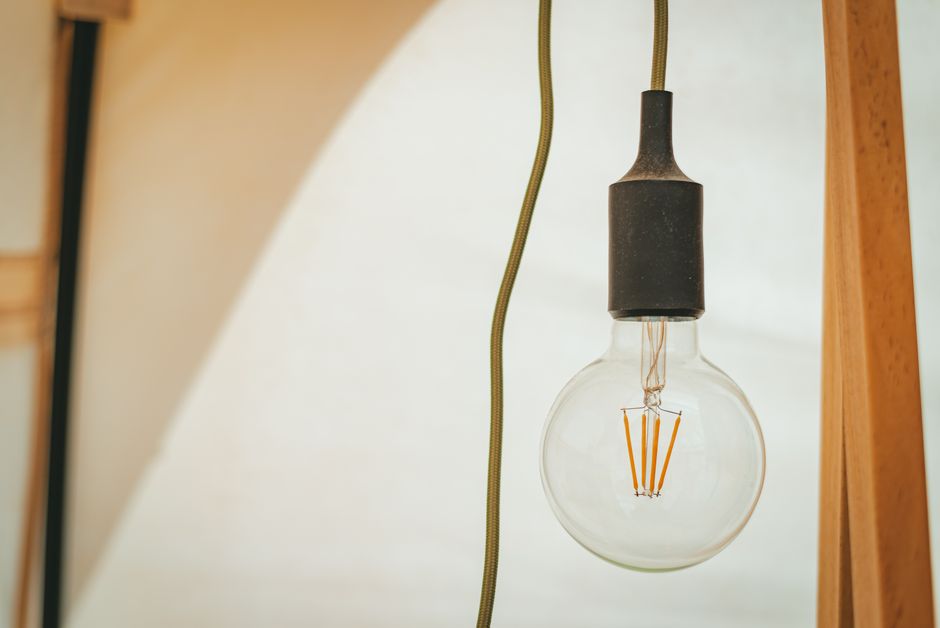 Close-up of a vintage-style incandescent light bulb hanging indoors, showcasing warm ambiance.