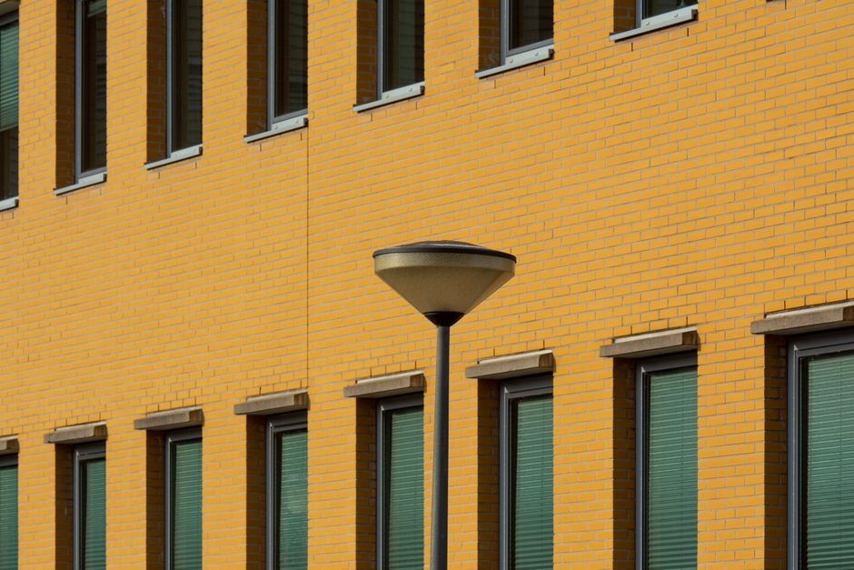 Yellow brick building wall with a modern street lamp. Urban architecture and design.