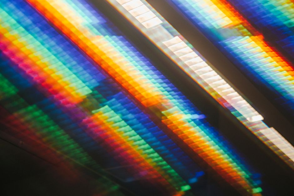 Colorful abstract image featuring a spectrum of rainbow light on a reflective surface.