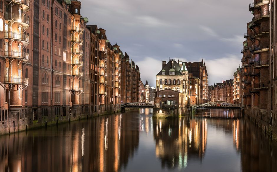 A picturesque view of Hamburg's historic Speicherstadt reflecting in the canal at twilight.