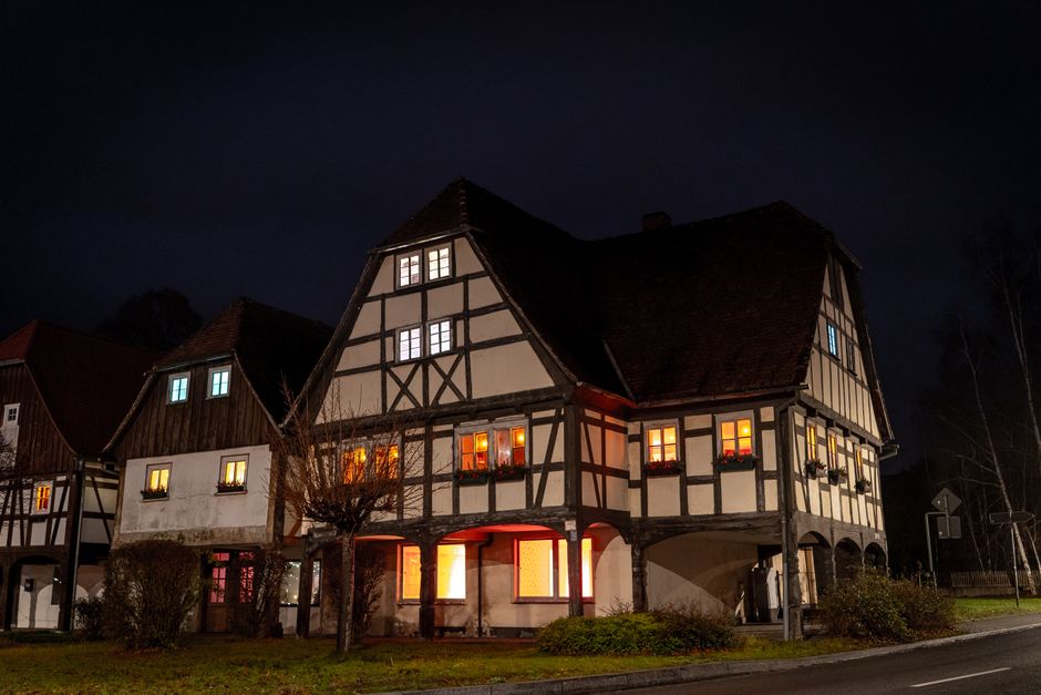 Charming medieval timbered house illuminated at night, showcasing Saxony's historic architecture.
