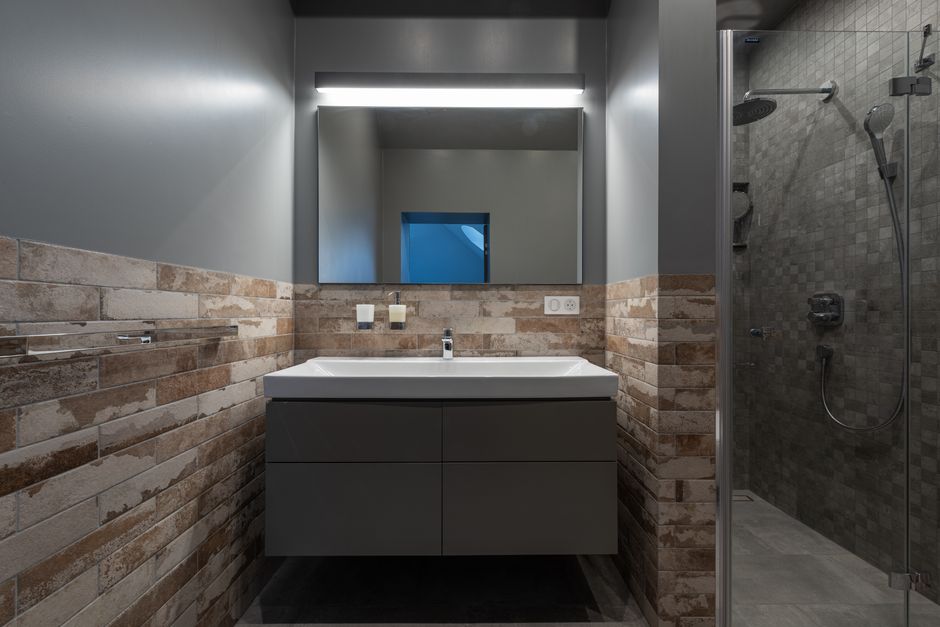 Contemporary bathroom with a glass shower and illuminated mirror.