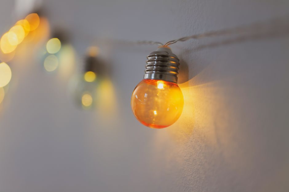 Close-up of a glowing orange bulb with bokeh background, creating a warm ambiance.