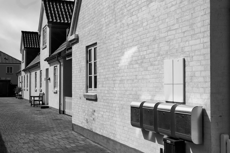 A black and white image of traditional Danish houses in a quaint courtyard.