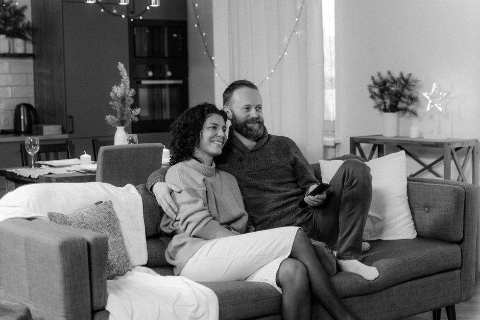 A happy couple enjoying a relaxing moment on the sofa in a stylish indoor setting.