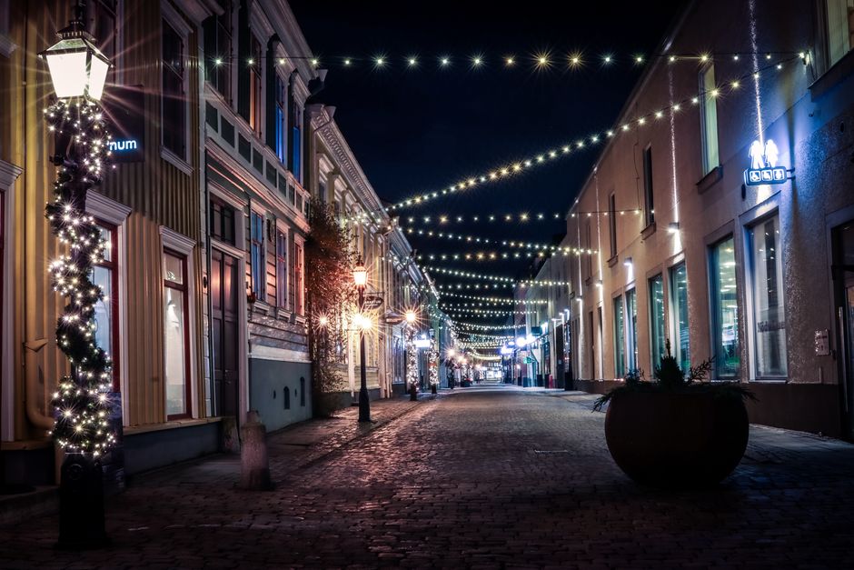 A beautifully lit street in Jönköping, Sweden featuring festive lights and cobblestone pavement.